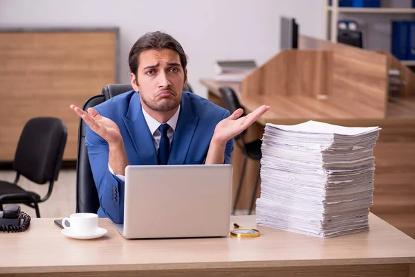 Joven empleado masculino descontento con el trabajo excesivo en la oficina — Foto de Stock