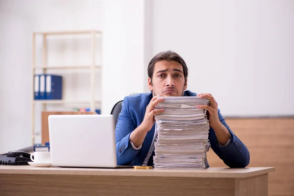 Giovane dipendente maschio infelice con un lavoro eccessivo in ufficio — Foto Stock