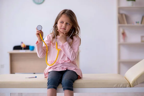 Kleines Mädchen mit Stethoskop wartet in Klinik auf Arzt — Stockfoto