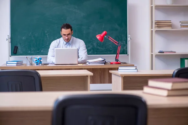 Jonge mannelijke leraar in de voorkant van groene boord — Stockfoto