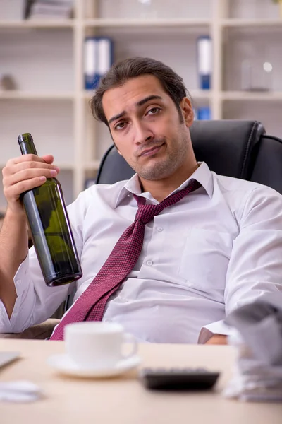 Empleado joven que bebe alcohol en la oficina — Foto de Stock