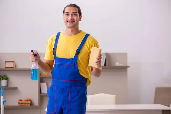 Jovem empreiteiro limpando a casa — Fotografia de Stock