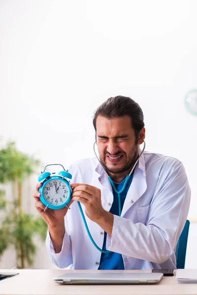 Joven médico masculino en concepto de gestión del tiempo —  Fotos de Stock