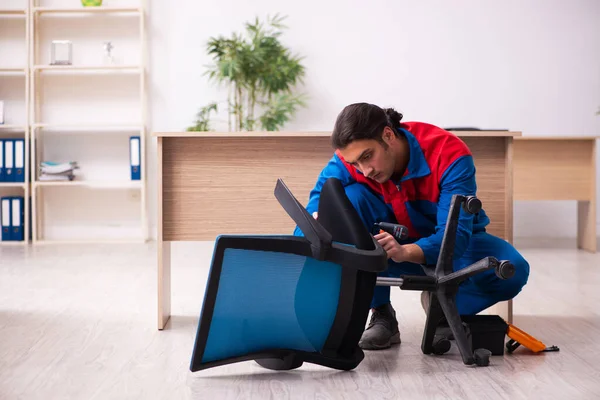 Ung manlig entreprenör reparera möbler på kontoret — Stockfoto