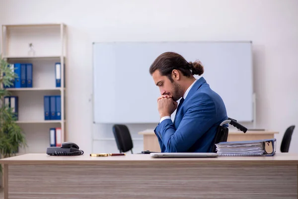 Young male employee in wheel-chair working in the office — Stock Photo, Image