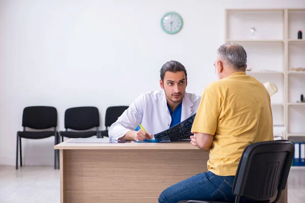 Fiatal férfi orvos radiológushoz látogató idős beteg — Stock Fotó