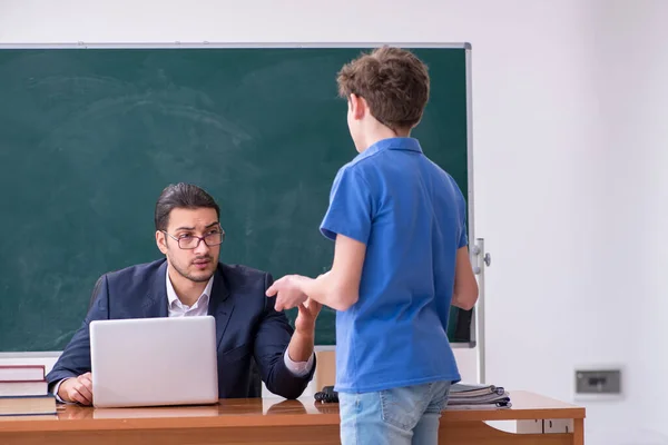 Young male teacher and schoolboy in the classroom — Stock Photo, Image