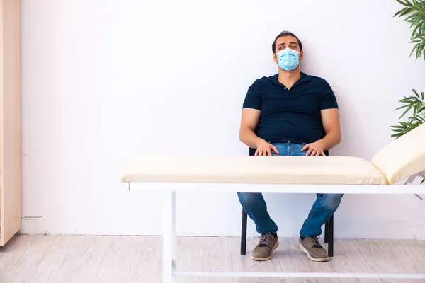 Jeune homme attendant un médecin pendant une pandémie à l'hôpital — Photo