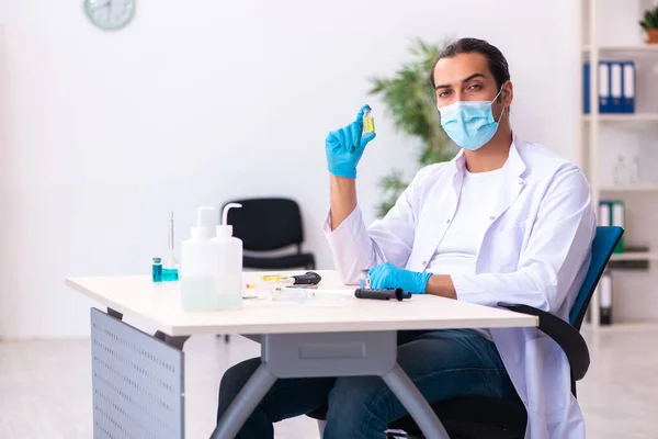 Jovem químico do sexo masculino trabalhando no laboratório durante a pandemia — Fotografia de Stock