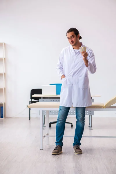Ung manlig läkare föreslår piller på kliniken — Stockfoto