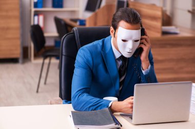 Ofiste maske takan genç bir erkek.