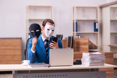 Ofiste maske takan genç bir erkek.