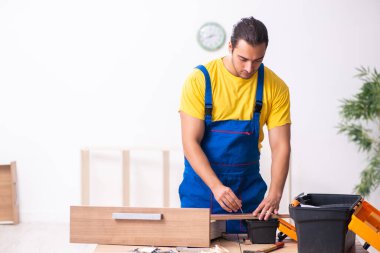 Genç erkek marangoz içeride çalışıyor.