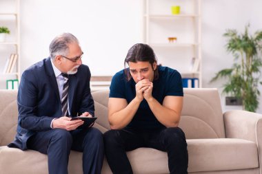 Genç adam yaşlı erkek psikoloğu ziyaret ediyor.