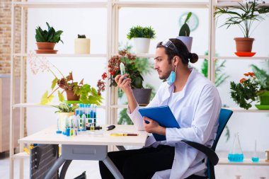 Laboratuvarda çalışan genç erkek kimyager parfümcüsü.