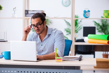 Ofiste çalışan genç bir erkek.