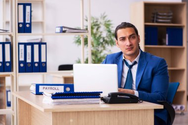 Genç yakışıklı çalışan ofiste oturuyor.