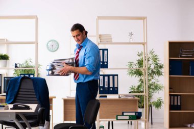 Genç erkek çalışan iş yerinde spor egzersizleri yapıyor.