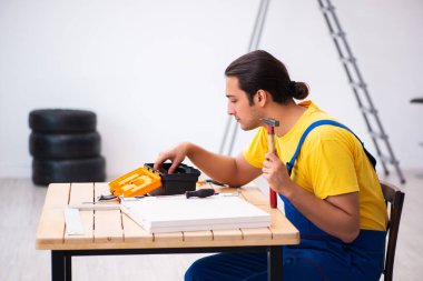 Genç erkek marangoz içeride çalışıyor.