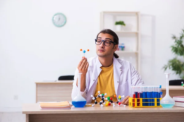 教室で分子モデルを学ぶ若い男性化学者 — ストック写真
