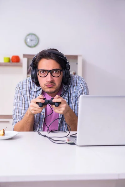 Jeune étudiant masculin jouant à des jeux informatiques à la maison — Photo