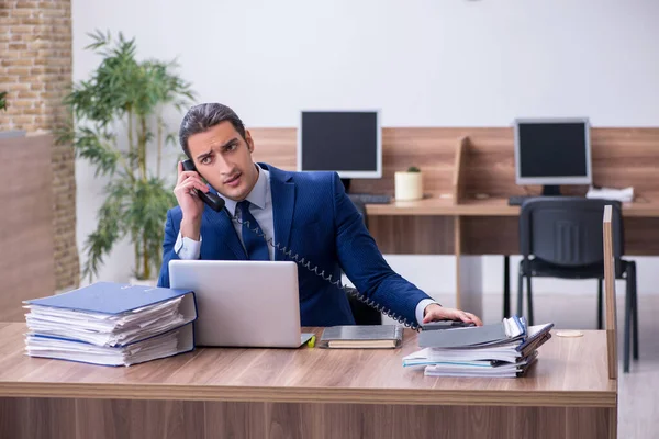 Jeune employé masculin malheureux avec un travail excessif — Photo