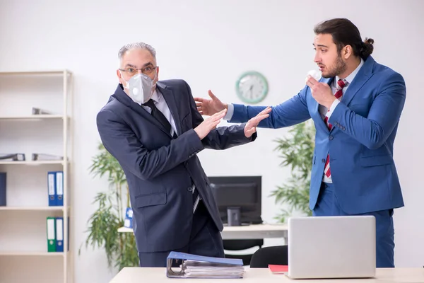 Dos empleados en el lugar de trabajo durante una pandemia — Foto de Stock