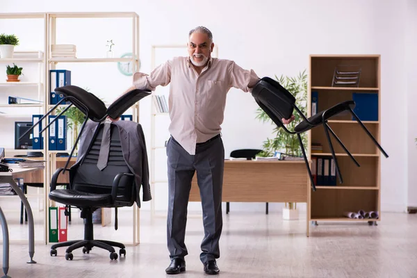 Starý muž zaměstnanec dělá fyzická cvičení na pracovišti — Stock fotografie