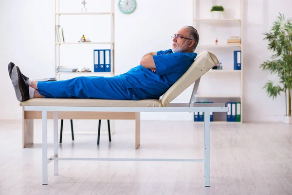 Old male doctor extremely tired after night shift — Stock Photo, Image