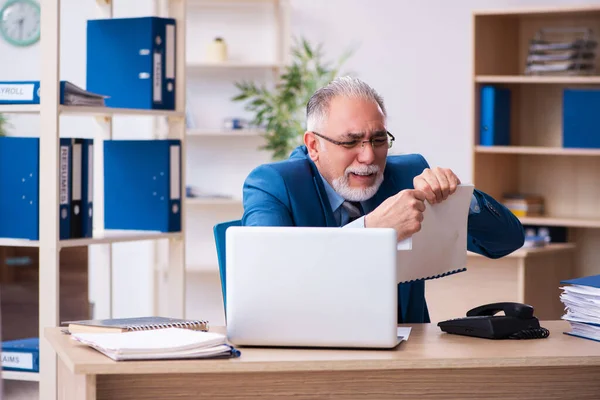 Viejo contable descontento con el trabajo excesivo en el lugar de trabajo — Foto de Stock