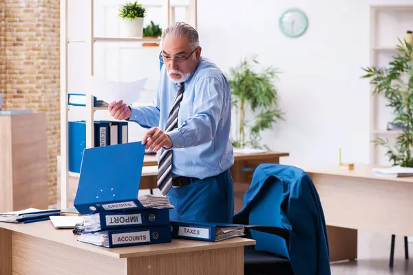 Velho contador masculino infeliz com excesso de trabalho no local de trabalho — Fotografia de Stock