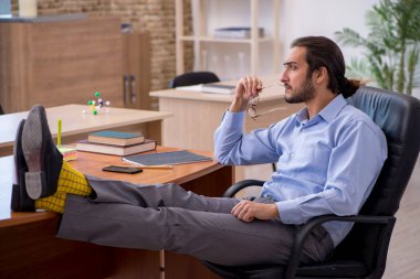 Genç erkek öğretmen salgın sırasında sınıfta.