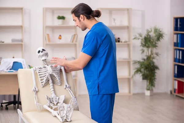 Ung manlig läkare och skelettpatient på kliniken — Stockfoto