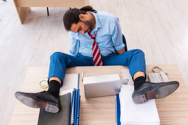 Joven empleado masculino descontento con el trabajo excesivo en la oficina — Foto de Stock