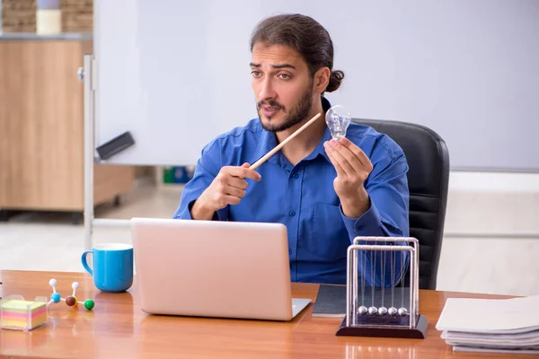 Young male teacher physicist sitting in the classroom — Stock Photo, Image