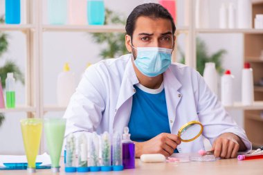 Genç erkek kimyager laboratuarda sabun test ediyor.