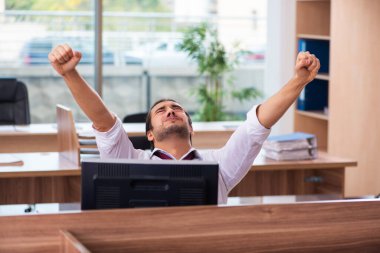 Genç bir erkek işçi ve ofiste çok fazla iş var.