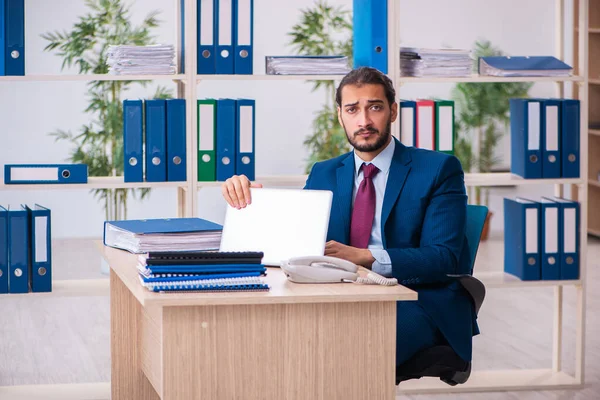 Genç bir erkek işçi ve ofiste çok fazla iş var. — Stok fotoğraf