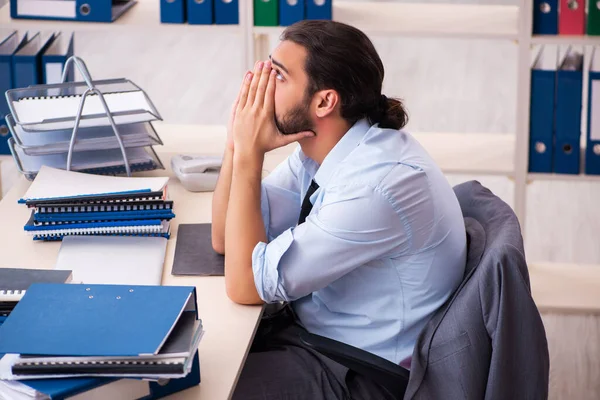 Jovem funcionário masculino infeliz com excesso de trabalho no escritório — Fotografia de Stock