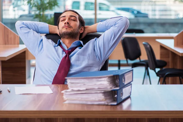 Jovem funcionário masculino infeliz com excesso de trabalho no escritório — Fotografia de Stock