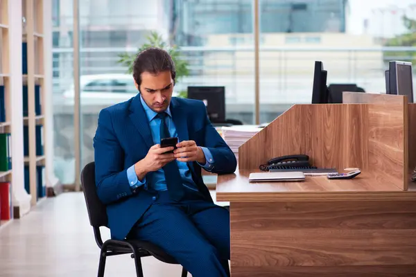 Jonge mannelijke werknemer werkzaam in het kantoor — Stockfoto