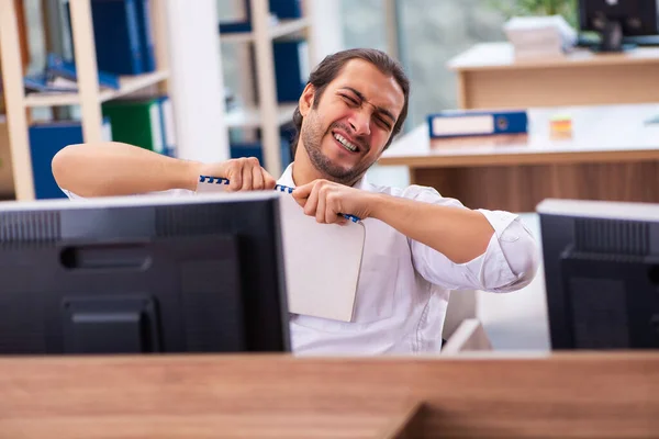 Young male employee and too many work in the office — Stock Photo, Image