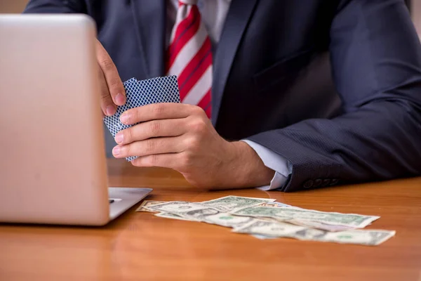 Young male employee playing cards at workplace