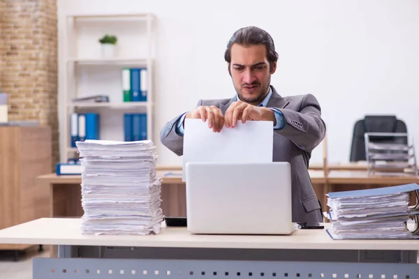 Joven empleado masculino descontento con el trabajo excesivo en la oficina — Foto de Stock