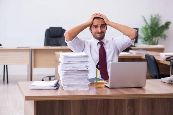 Joven empleado masculino descontento con el trabajo excesivo en la oficina — Foto de Stock