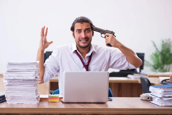 Giovane dipendente maschio infelice con un lavoro eccessivo in ufficio — Foto Stock