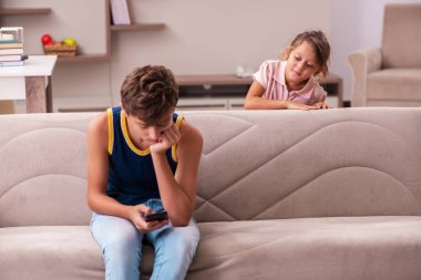 Oğlan ve küçük kız kardeşi salgın sırasında evde kalıyorlar.