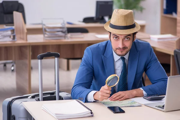 Young male employee preparing for trip in the office — Stock Photo, Image
