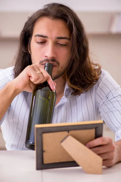 Jongeman die thuis alcohol drinkt in ongelukkig liefdesconcept — Stockfoto