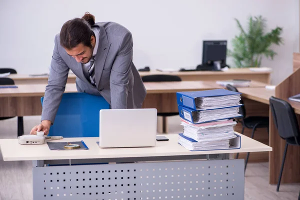 Giovane dipendente maschio infelice con un lavoro eccessivo in ufficio — Foto Stock